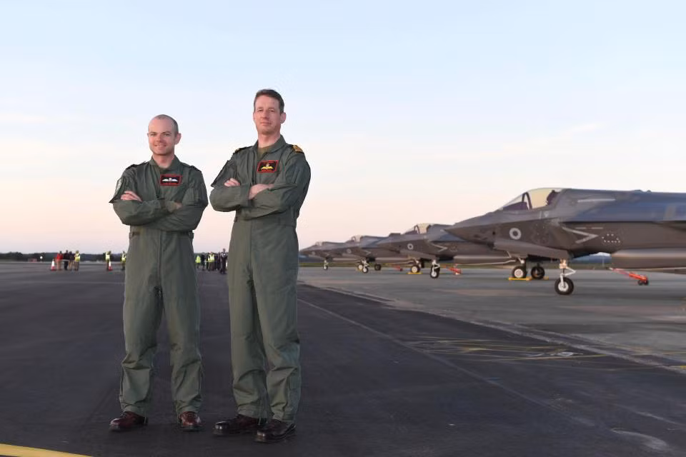 Trung úy không quân John Butcher (trái) và đồng nghiệp tại đứng trên đường băng của căn cứ RAF Marham.