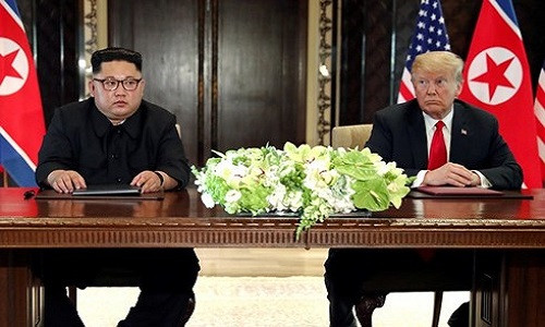 Nhà lãnh đạo Triều Tiên Kim Jong-un và Tổng thống Mỹ Donald Trump ngồi vào bàn ký kết thỏa thuận lịch sử. Ảnh: Reuters