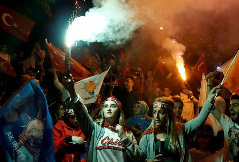 Những người ủng hộ Đảng AK đốt pháo sáng và vẫy cờ bên ngoài trụ sở đảng này ở Istanbul, Thổ Nhĩ Kỳ.
