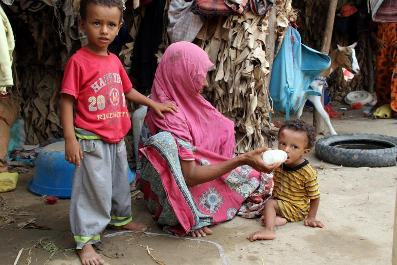 Người phụ nữ cho con ăn trong túp lều tạm bợ của họ tại khu trại tị nạn gần Aden.