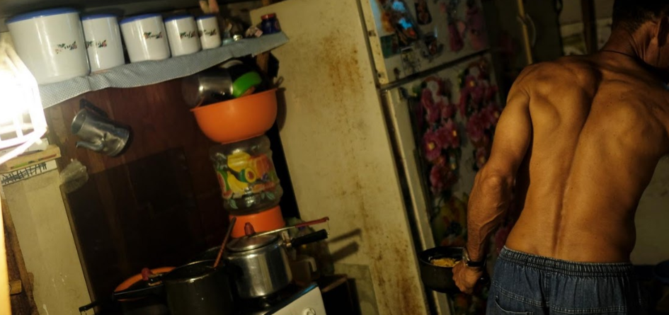 Người đàn ông nấu ăn trong không gian chật hẹp.