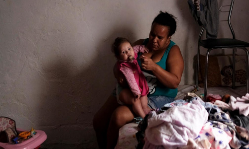 Người phụ nữ cho con ăn trong căn phòng chật chội. Mời độc giả xem thêm video: Mất 2.000 USD để trở thành người vô gia cư (Nguồn: VTC14)