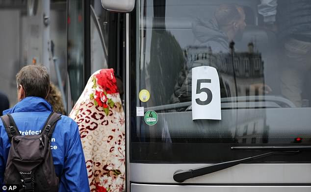 Những người dân nhập cư lên xe buýt ở Paris. Ảnh: AP.