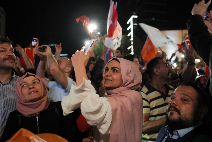 Người phụ nữ chụp ảnh trong lúc Tổng thống Erdogan phát biểu trước đám đông tại trụ sở AKP ở Ankara.