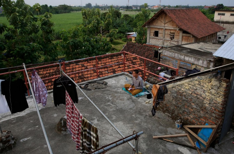 Nam sinh ngồi trên sân thượng trong ký túc xá của trường để đọc kinh Koran.