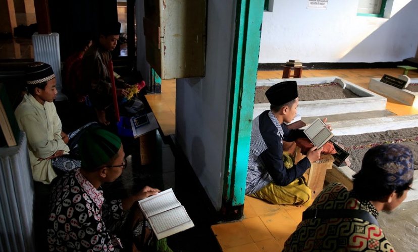 Các sinh viên đọc kinh thánh trước những ngôi mộ tổ tiên.