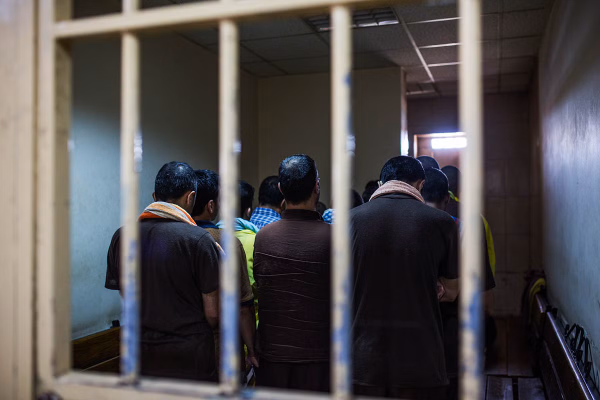 Các tù nhân nam chờ trong một phòng giam của tòa án ở Baghdad, Iraq.