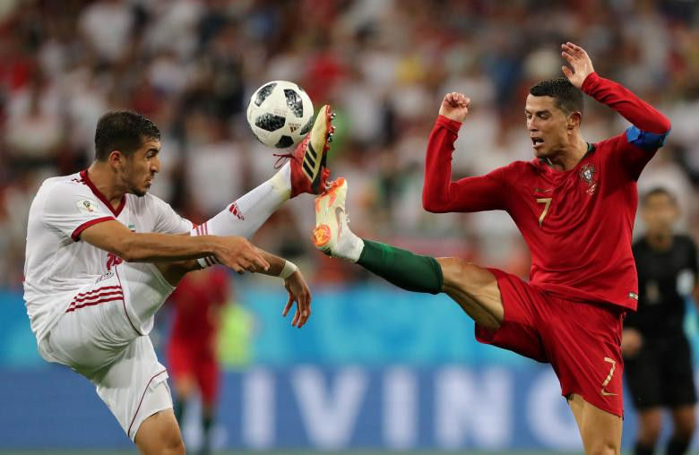 Pha tranh chấp bóng giữa cầu thủ Majid Hosseini của Iran với Cristiano Ronaldo của Bồ Đào Nha.