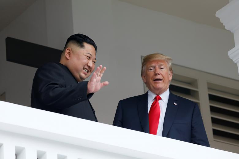 Nhà lãnh đạo Kim Jong-un cười tươi vẫy tay chào khi đứng cạnh Tổng thống Trump tại khách sạn Capella. Ảnh: Reuters.