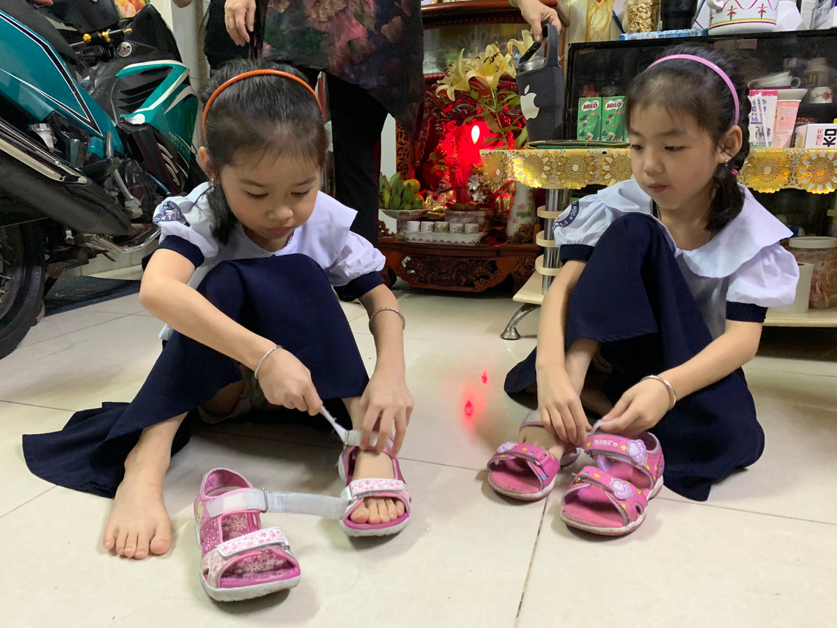 2 bé gái đang chuẩn bị đến trường.