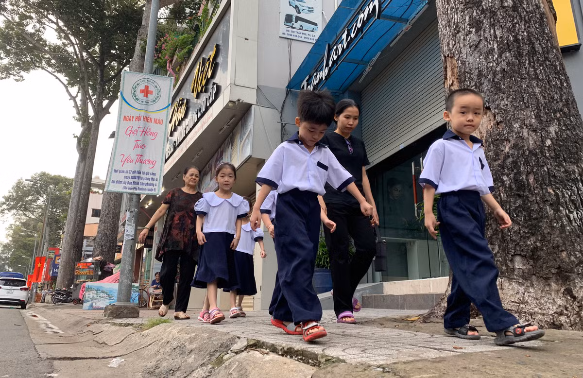 Các bé được bà nội và mẹ đưa đến trường.