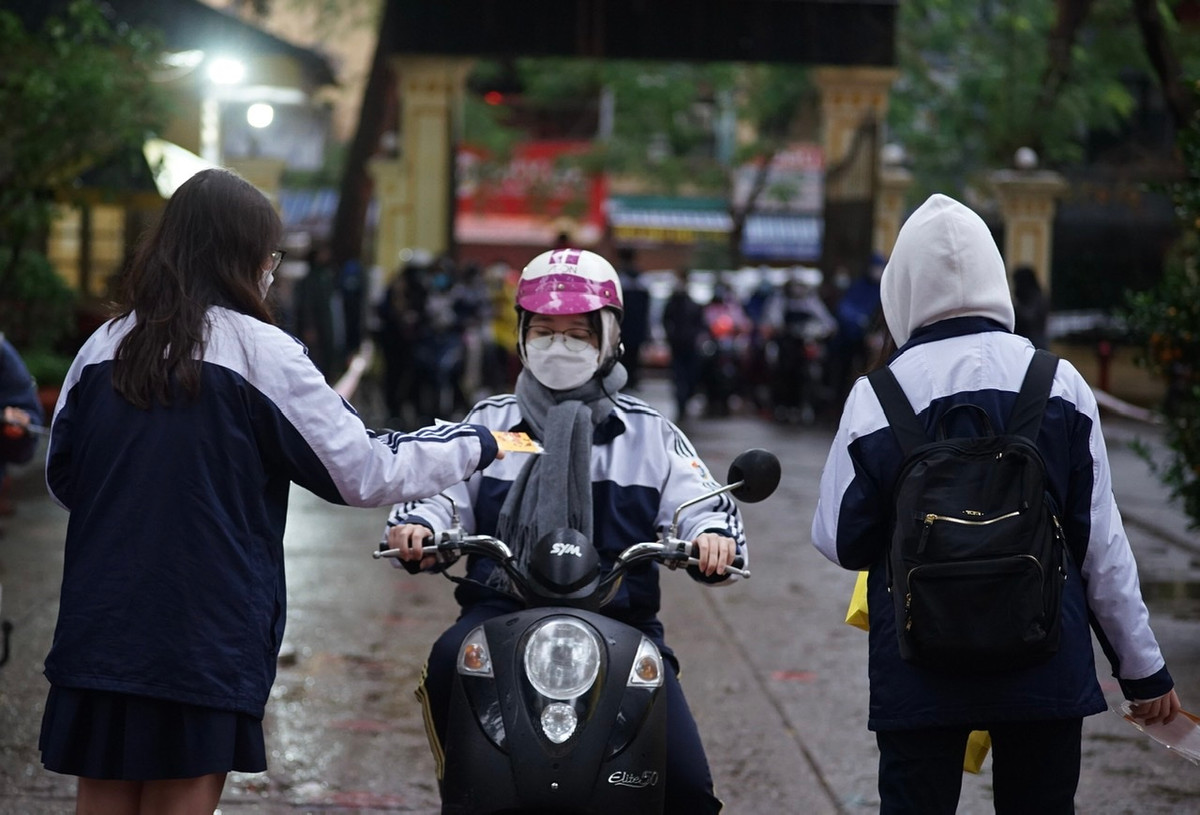 Tại trường THPT Việt Đức (Hoàn Kiếm, Hà Nội), các bạn học sinh chờ sẵn cổng trường để lì xì đầu năm mới cho bạn bè.