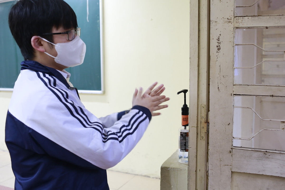 Học sinh được yêu cầu khử khuẩn tay trước khi vào lớp học.
