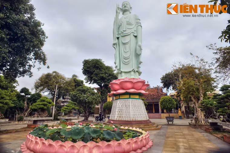 Tượng được xây bằng đá xanh đặt trên đài sen, phía trước là hồ sen, xung quanh nhiều cây xanh tạo nên một không gian tĩnh mịch, trang nghiêm.