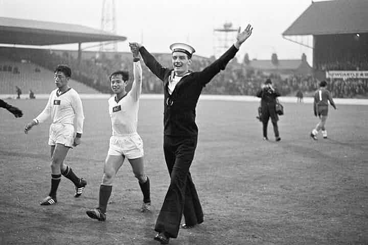 Một bức ảnh cho thấy khả năng kết nối con người của bóng đá: Một thủy thủ Anh cầm tay cầu thủ CHDCND Triều Tiên Pak Seung Zin trên sân cỏ sau trận Triều Tiên hòa Chile tại World Cup 1966. Ảnh: The Guardian.