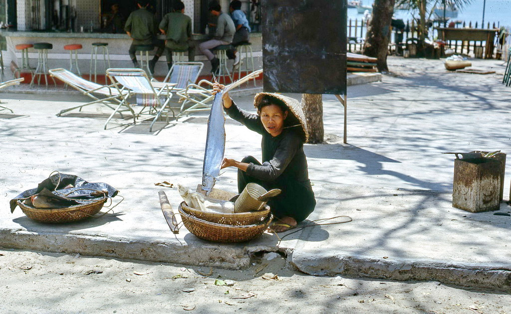 Người phụ nữ bán cá khoe con cá lớn đánh bắt được ở Vũng Tàu. Ảnh: Terry Maher.