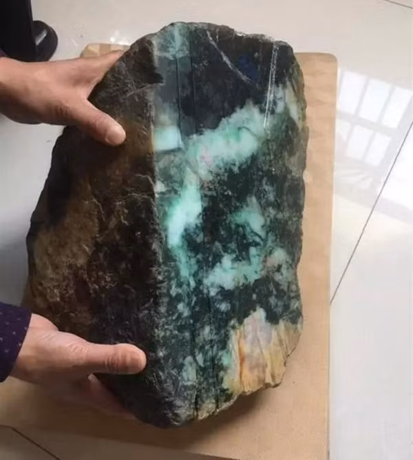 Được một người giới thiệu một viên đá quý dạng thô nặng tới 80 kg, lão Vương đến từ Quảng Châu đã xuống tiền mua về nhà. Khi cắt thử lần đầu tiên, ông có phần thất vọng vì chẳng khác gì là một viên đá thải loại.