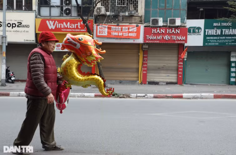 Gần như tất cả các cửa hàng buôn bán trên đường phố Hà Nội đã đóng cửa trong chiều 30 Tết (9/2), đường phố ít người đi lại.