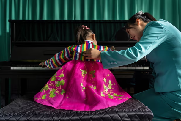 Theo Guardian, Triều Tiên là đất nước này có hệ thống chính trị riêng biệt và bản sắc văn hóa độc đáo. Những hình ảnh từ cuốn sách của Tariq Zaidi phần nào hé mở cuộc sống thường nhật của người dân nơi đây. Ảnh: Một bé gái trong trang phục truyền thống chơi piano tại trường mẫu giáo Chongam ở Chongjin, Triều Tiên. (Nguồn ảnh: The Guardian)