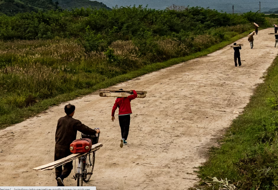 Người dân khiêng những tấm ván gỗ ở một vùng nông thôn trên con đường nối giữa núi Kumgang và hồ Sijung.