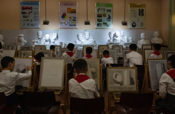 Bên trong một lớp học vẽ tại Cung thiếu nhi Mangyongdae ở Bình Nhưỡng, thủ đô Triều Tiên. Cung thiếu nhi Mangyongdae là cơ sở dành cho các hoạt động sau giờ học của trẻ em. Nó có 120 phòng, một bể bơi, sân bóng rổ và bóng chuyền và một nhà hát 2.000 chỗ ngồi.