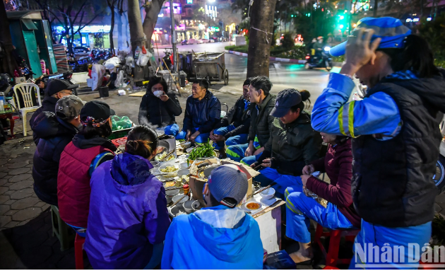 "Bàn ăn" được dựng từ vài chiếc hộp xốp đã cũ, phía trên phủ bạt. Ghế ngồi thì mỗi người mang theo một chiếc. Chỉ chừng 10 phút, mâm cơm tất niên của những công nhân môi trường tối 29 Tết đã sẵn sàng.
