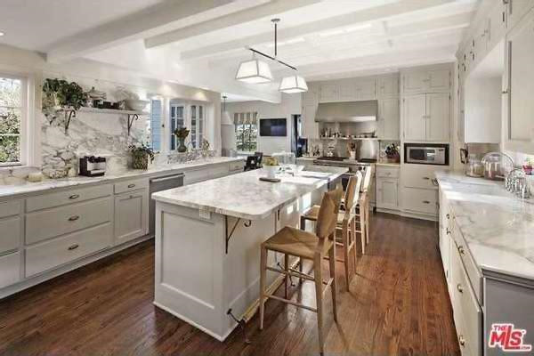 Nhà bếp sáng sủa mang tông màu trắng chủ đạo được lát đá cẩm thạch cùng các trang thiết bị cao cấp, hiện đại.