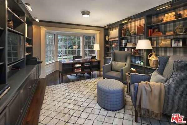 Thư viện kết hợp văn phòng làm việc sang trọng cũng mang những gam màu tối chủ đạo với các kệ sách khổng lồ và khung cửa sổ đem đến cảnh sắc sân vườn.