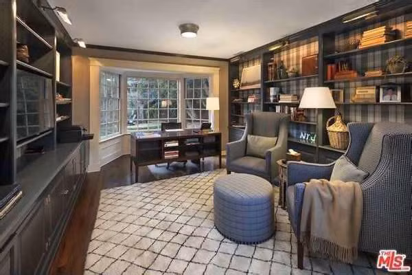 Thư viện kết hợp văn phòng làm việc sang trọng cũng mang những gam màu tối chủ đạo với các kệ sách khổng lồ và khung cửa sổ đem đến cảnh sắc sân vườn.