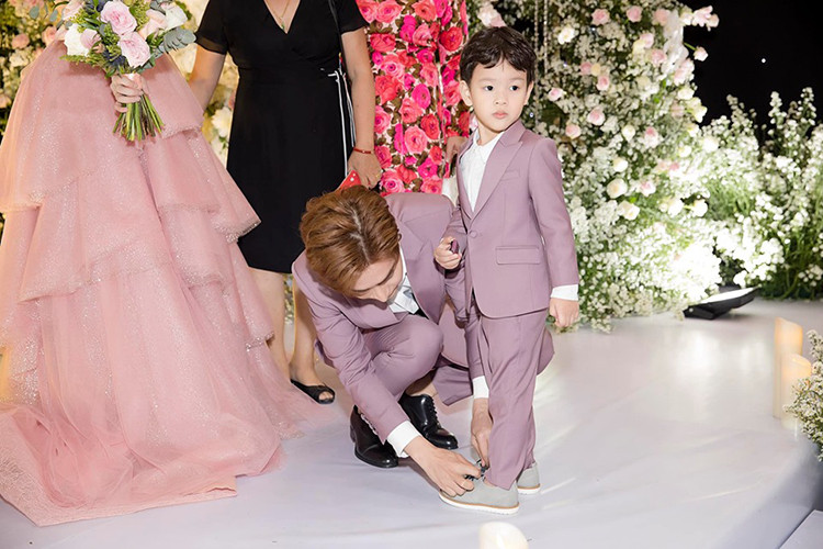 Hình ảnh Kin Nguyễn cúi người buộc dây giày cho bé Henry trong đám cưới từng gây chú ý.