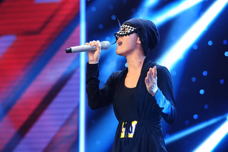 Năm 2014, Anh Thúy (nhóm Mây Trắng) đeo mặt nạ giả danh thí sinh Huyền Minh tham gia Nhân tố bí ẩn. Ảnh: Đời sống pháp luật