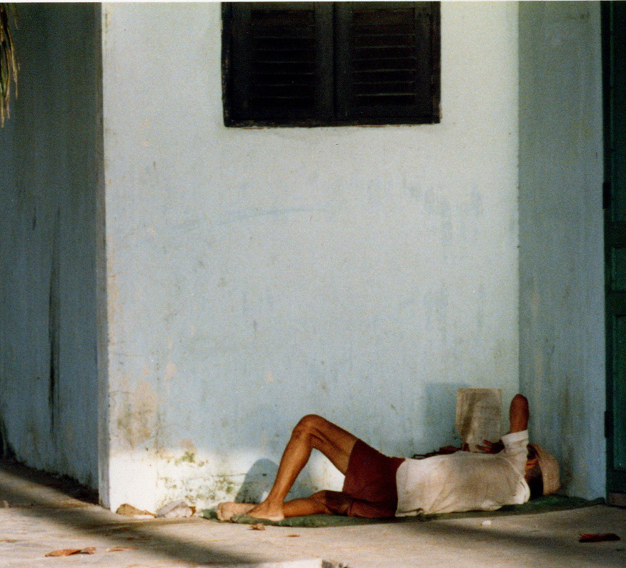 Một người nằm đọc báo.