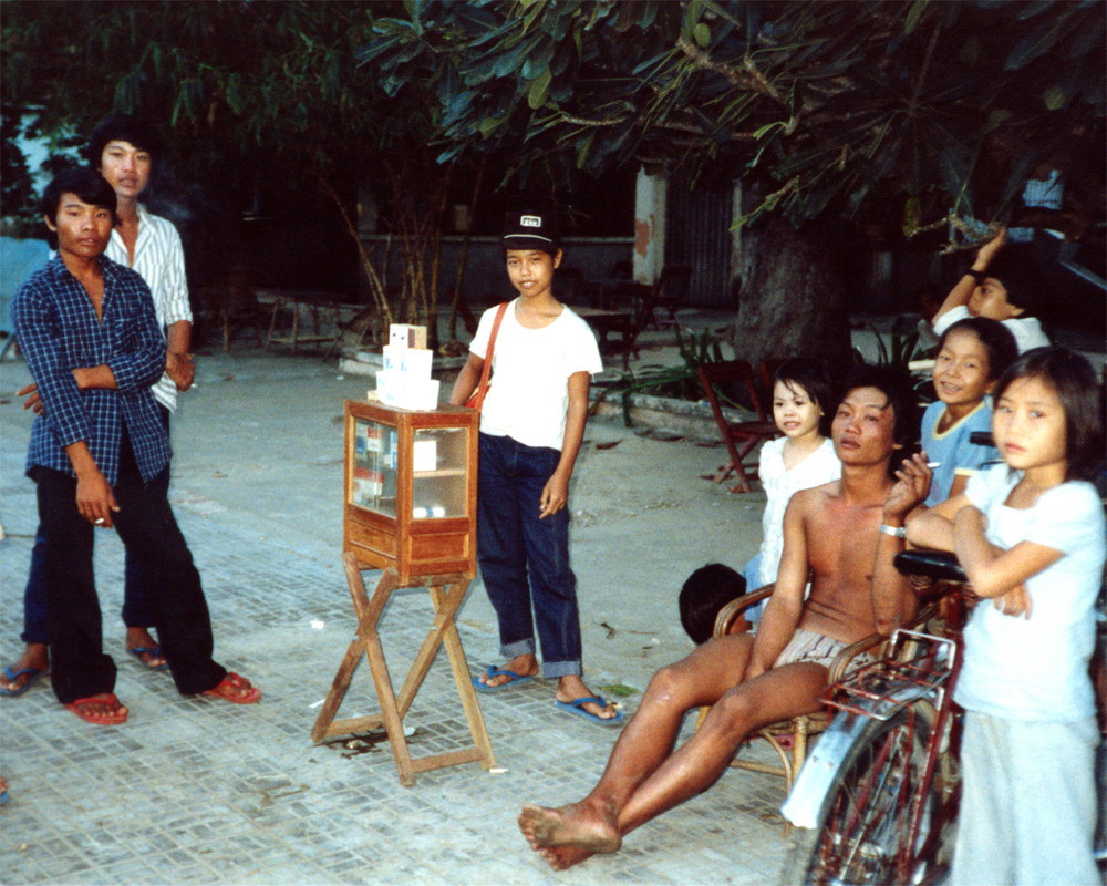 Cậu bé bán thuốc lá vỉa hè cùng chúng bạn ở xung quanh.