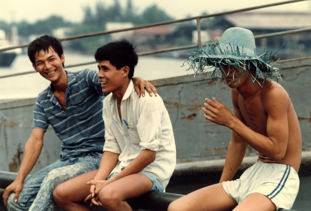 Các thanh niên ngồi trên thành cầu tán gẫu.