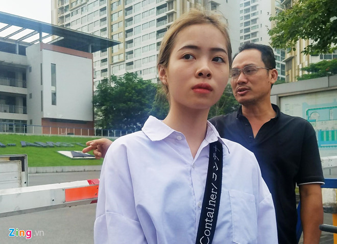 Một nữ sinh cho biết bạn hứa sẽ qua đón nên em đưa giấy tờ nhờ cầm hộ. Gần 7h15, em đứng trước cổng trường nhưng không gặp bạn, cũng không thể liên lạc vì bạn không cầm theo điện thoại. Nữ sinh tỏ ra rất lo lắng. Cuối cùng, một tình nguyện viên dẫn em vào trường để giải quyết vấn đề. Ảnh Zing