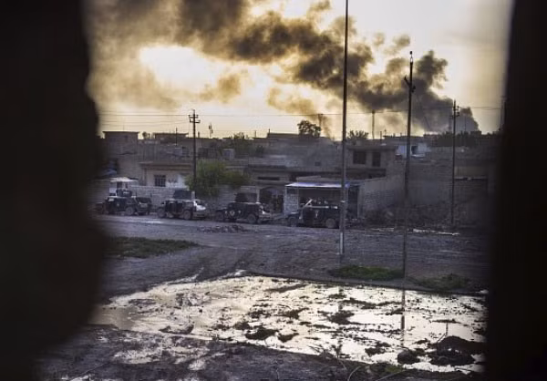 Khói bốc lên từ phía sau khi Sư đoàn 2 Lực lượng Đặc nhiệm Iraq giao chiến với phiến quân IS ở khu dân cư Đông Samah và Arbagiah ở trong thành phố Mosul. Ảnh FNA