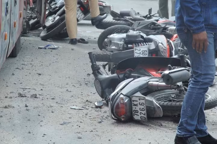 Tại hiện trường xe khách tông xe máy dừng đèn đỏ, 7 xe máy bị xe khách tông văng khắp trên mặt đường, một xe tải cũng bị tông biến dạng phần hông xe.