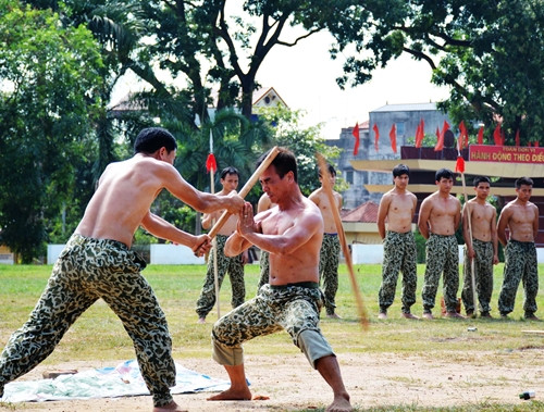 Vận công đỡ gậy gỗ đập lên đầu.