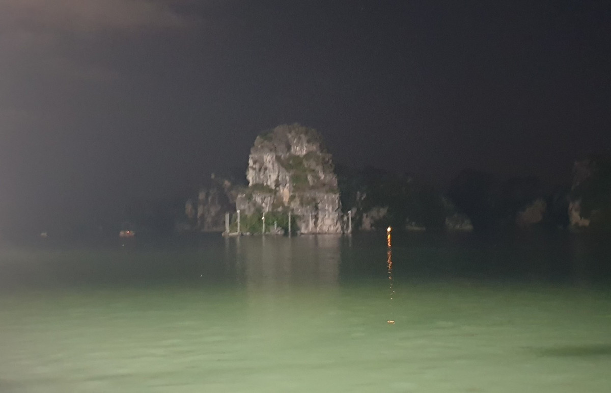 Một số núi đá vẫn chìm trong bóng tối, trơ trọi giữa vịnh Hạ Long mặc dù cũng đang bị giàn điện quấn chặt xung quanh.