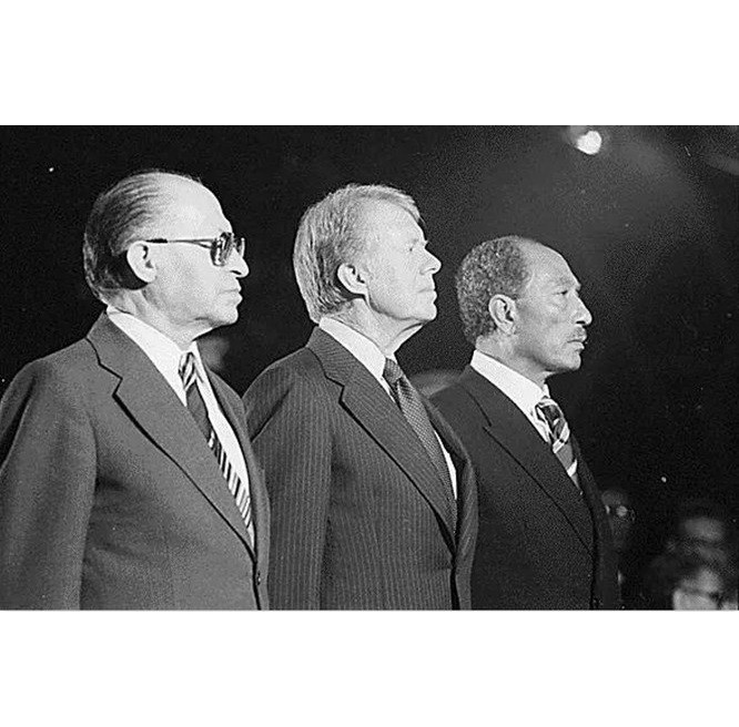 Vào ngày 6/10/1973, các quốc gia Ả Rập do Ai Cập, Syria đứng đầu và quân du kích Palestine nhân “Ngày lễ Rửa tội” của Do Thái giáo đã tiến hành một cuộc đột kích vào Israel. Quân đội Israel lúc đầu lâm vào tình trạng hỗn loạn chưa từng có, thậm chí quân đội Ai Cập đã đuổi được người Israel ra khỏi bán đảo Sinai. Quân đội Ả Rập trên tất cả các mặt trận cũng đã phá vỡ tuyến phòng thủ của quân đội Israel. Mười lăm phút sau khi chiến tranh bùng nổ, Đài phát thanh Israel đã công bố các mệnh lệnh của Bộ Quốc phòng và thông báo qua điện thoại, điện báo, thư, đài phát thanh... yêu cầu tất cả các quân nhân ngạch dự bị ngay lập tức đến các địa điểm được chỉ định. Ảnh: Tổng thống Mỹ (giữa) và Thủ tướng Israel (trái), Tổng thống Ai Cập (phải) gặp nhau ký kết Hiệp ước hòa bình Trại David sau Chiến tranh Ngày lễ Rửa tội năm 1973
