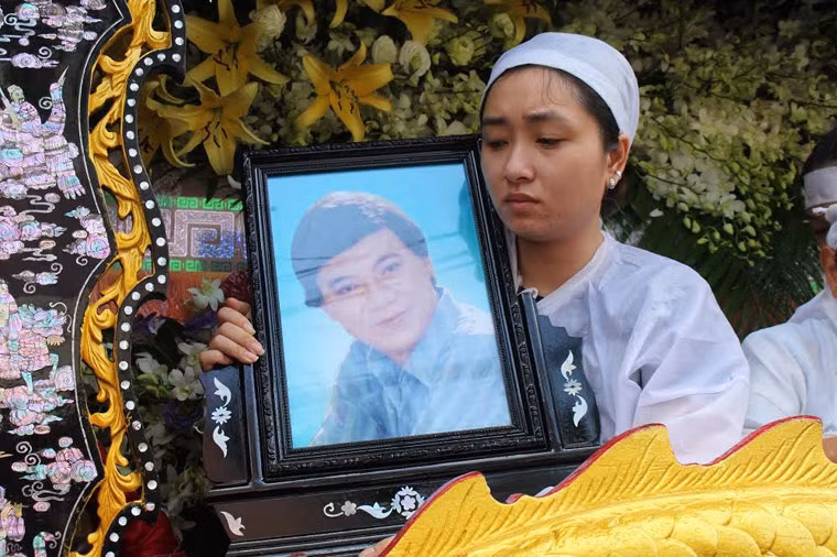 Con gái NSƯT Thanh Sang bên di ảnh và quan tài cha.