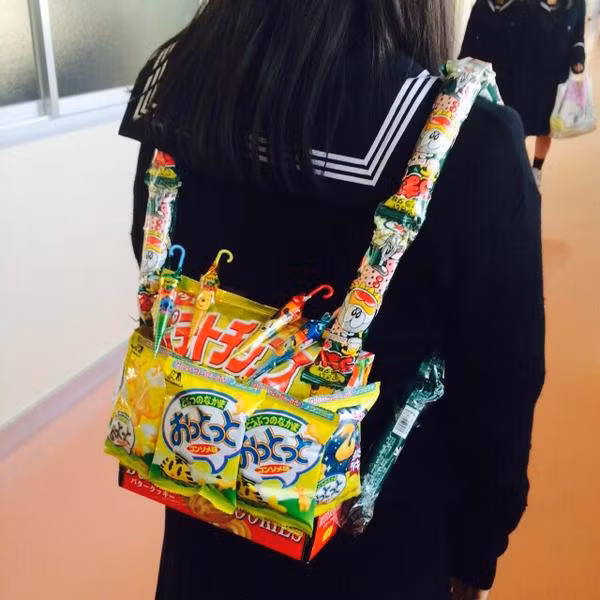 Thay bằng chất liệu vải, da thông thường... những chiếc ba lô, túi xách của nữ sinh Nhật Bản nay được làm hoàn toàn bằng những gói quà vặt, bánh kẹo đầy màu sắc.