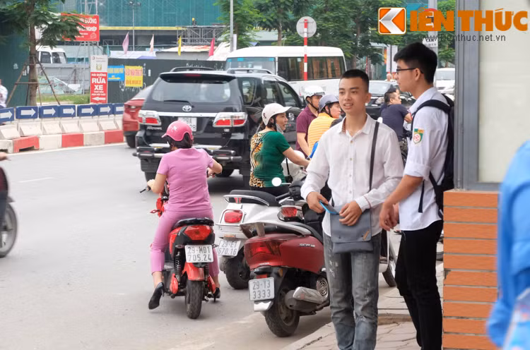 Hai sĩ tử tranh thủ trao đổi thông tin ngoài cổng trường.