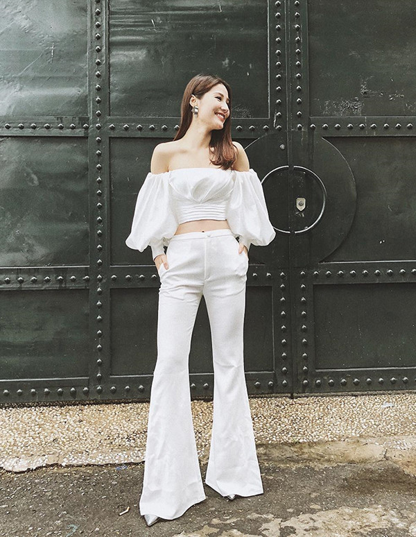 Diễm My đẹp tinh khôi khi phối hợp áo trễ vai màu trắng với quần loe cùng màu. Ảnh: hanghieuorder.