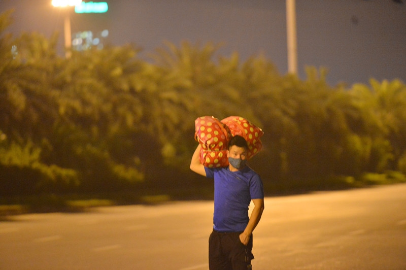 Công nhân vác theo túi đồ đạc, lỉnh kỉnh đi bộ về quê.