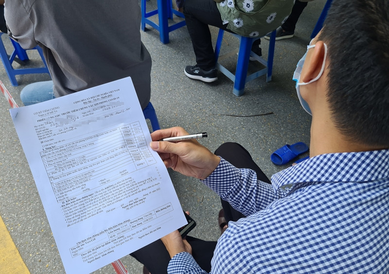 Người dân khai báo thông tin trước khi tiêm vắc xin phòng COVID-19.