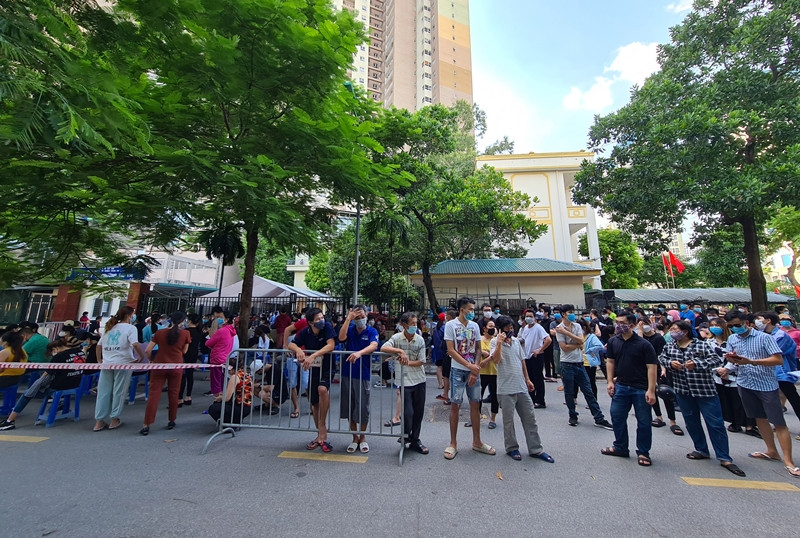 Trong khoảng thời gian chờ đến lượt tiêm, người dân dân đứng ở lòng đường trò chuyện, không đảm bảo giữ khoảng cách.