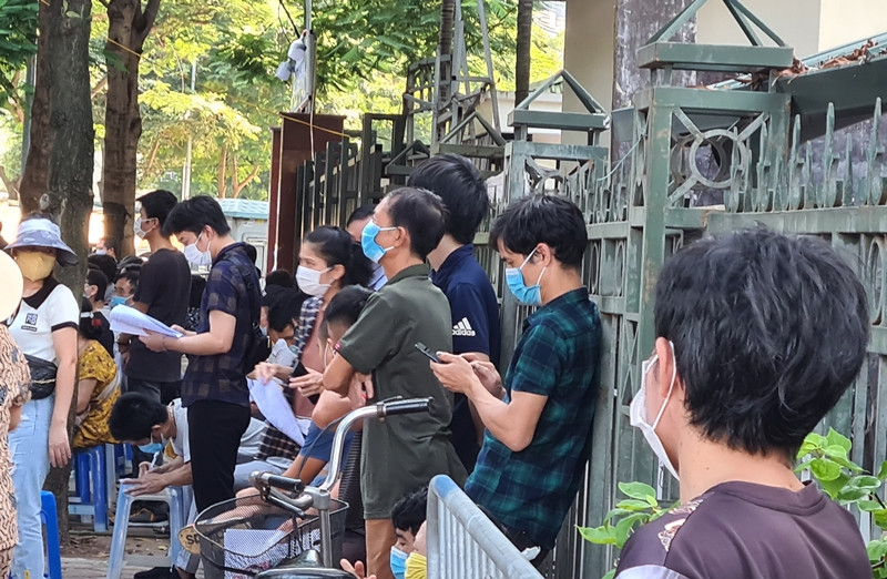 Người dân tập trung đông, vật vạ trước cổng trạm y tế phường Mễ Trì chờ đến lượt vào tiêm vắc xin.