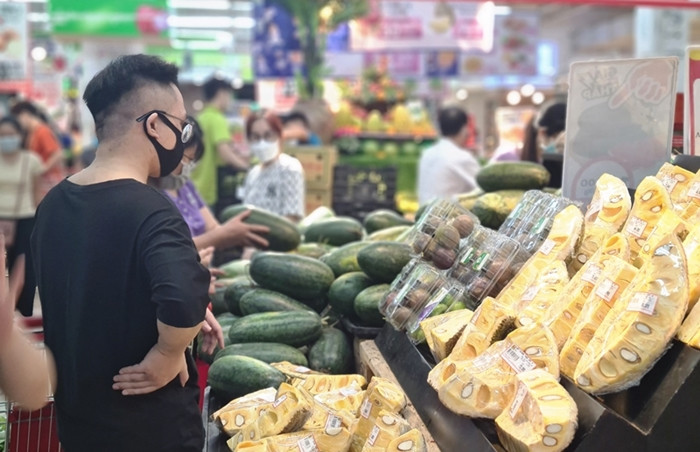 Nam khách hàng quan sát kỹ giá trái cây trước khi chọn mua.