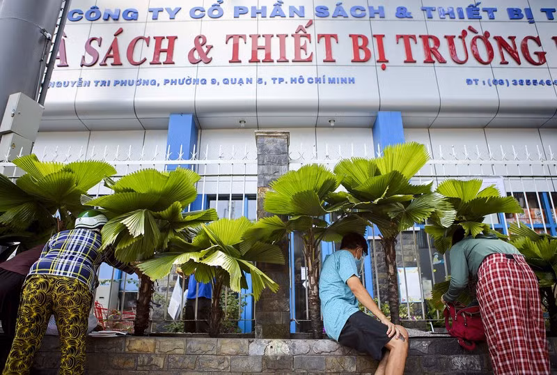 Ghi nhận tại cửa hàng sách trên đường Nguyễn Trị Phương quận 5, TP.HCM, phụ huynh phải đặt hàng, thanh toán qua hàng rào của cửa hàng sách.